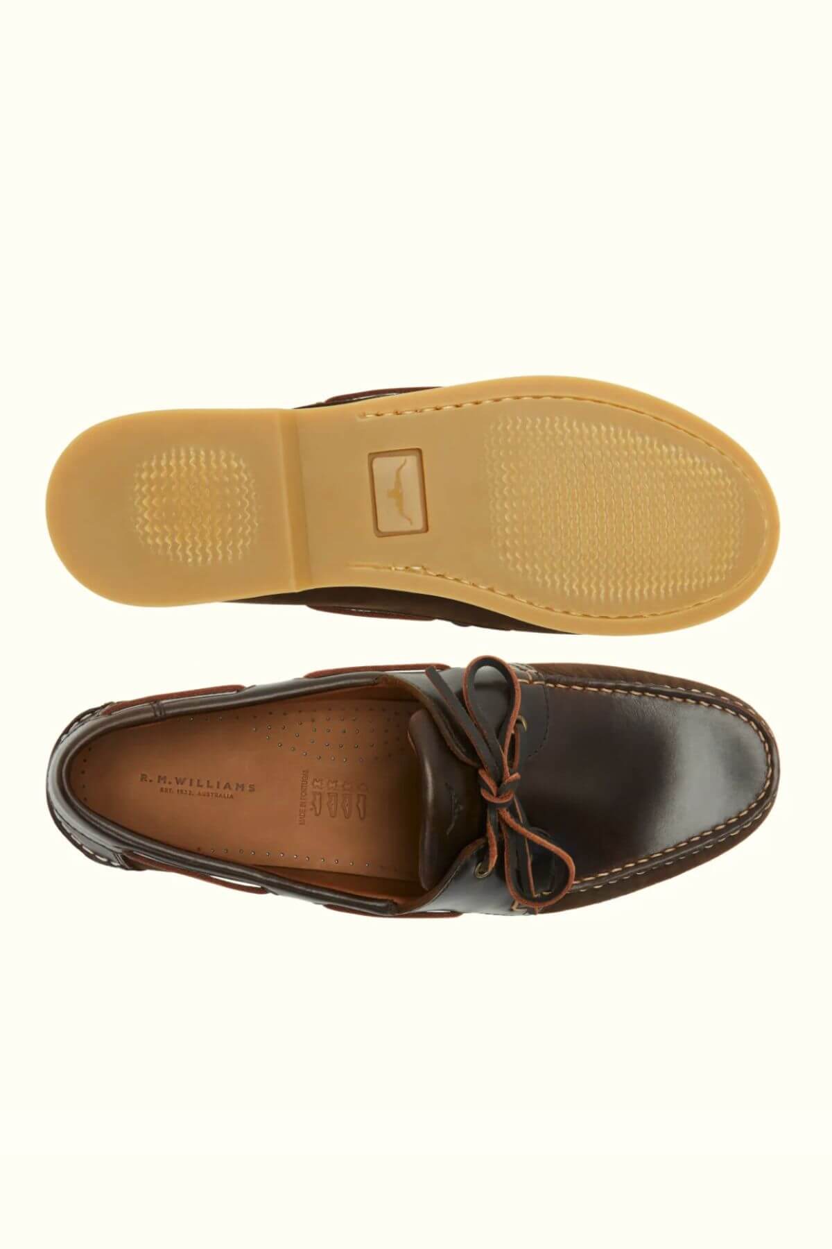 Top and side views of the RM Williams Hobart Boat Shoe in brown bovine leather with moccasin construction, tan rubber sole, visible stitching, leather laces, and perforated insole shown on a light background.