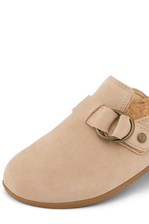 Close-up of the REEF Vista Serenity tan suede slip-on for women, featuring a cork insole, gold buckle, rounded toe, flat sole, and minimalist design.