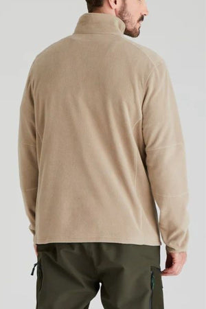A man is seen from behind in a beige Ridgeline Narvik Fleece zip-neck jacket and dark green pants, set against a plain light gray background, emphasizing comfort and outdoor performance.