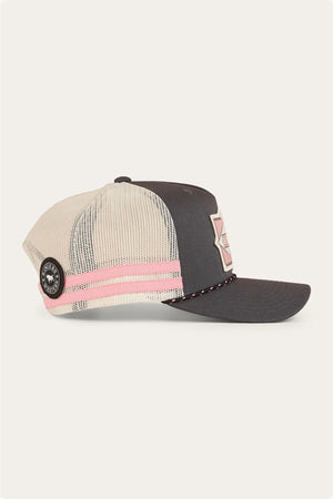 The Ringers Western Hometown Trucker Cap has a dark gray bill and front, cream mesh back, pink and white stripes, a round black side patch, a geometric front patch, and an adjustable snapback.