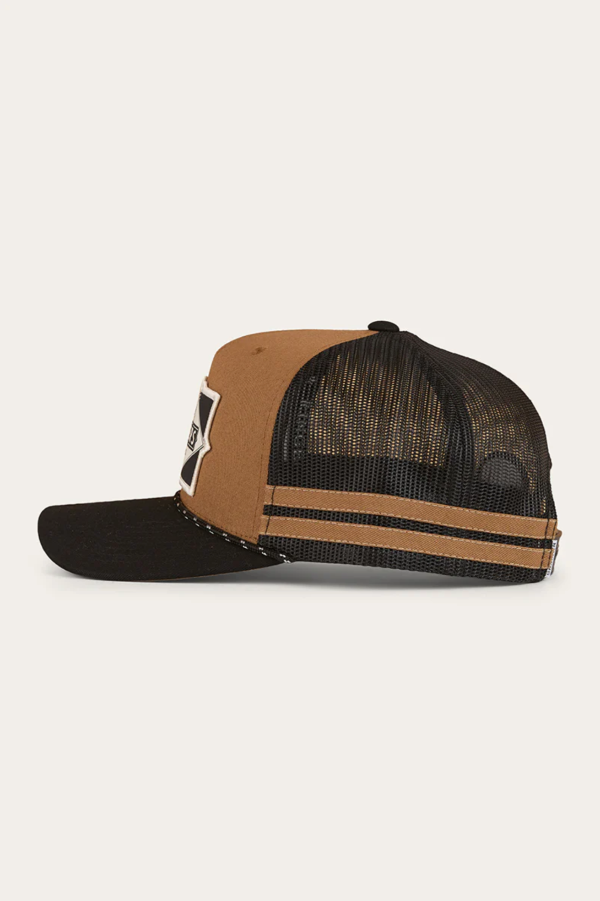 Side view of the Ringers Western Hometown Trucker Cap showing its deep fit, brown front panel, black mesh back with two brown stripes, black curved brim, adjustable snapback, and a partly visible front patch.