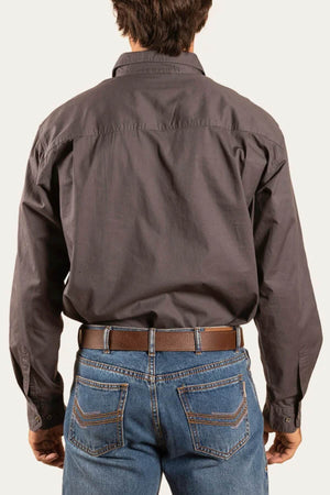 A person seen from behind wears a dark Ringers Western King River Half Button Shirt tucked into blue jeans with a brown belt, set against a plain light background.