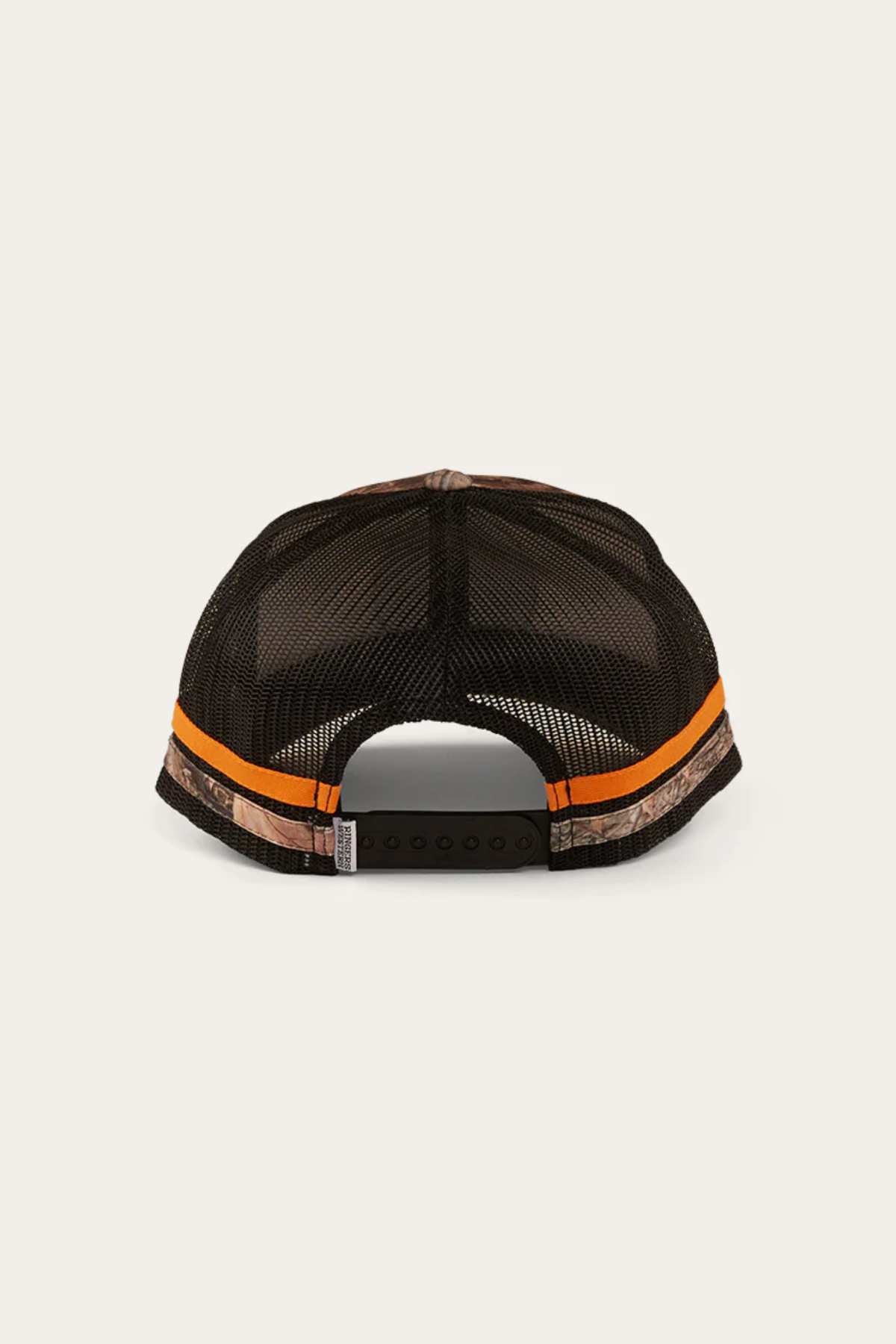 The Ringers Western McCoy Trucker Cap is a black mesh trucker cap with camo-patterned sides, two orange stripes on the back, and an adjustable snapback. It showcases the classic Ringers Western design on a light neutral background and is made from premium cotton twill for durability and style.