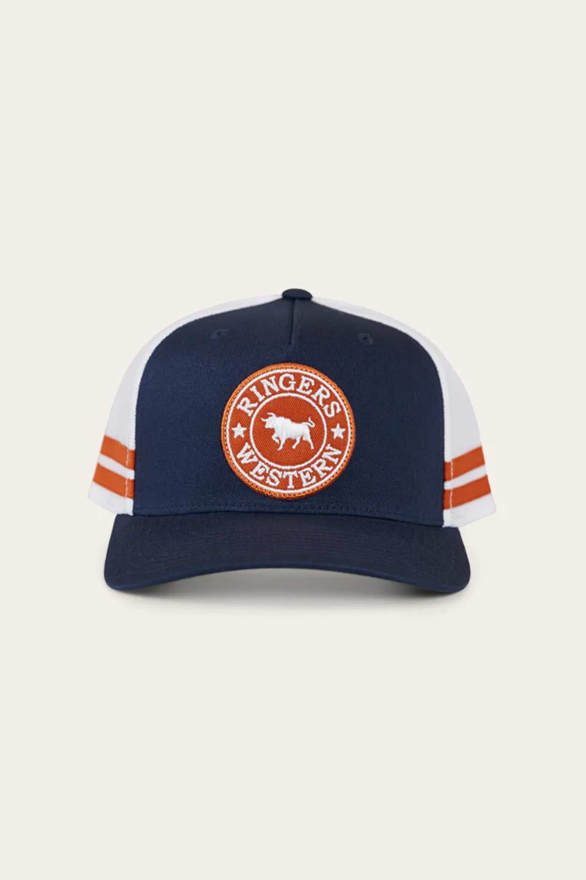 The Ringers Western McCoy Trucker Cap is a navy-blue and white hat featuring a circular orange cotton twill patch with a cow and the words "Ringer's Western" on the front, along with orange double stripes on both sides.