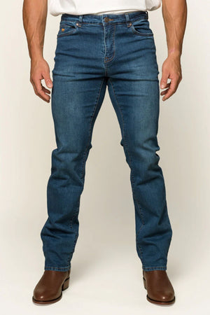 A person wears Ringers Western brown boots with Mitchell Mens Straight Leg Jeans and a crisp white shirt, standing against a plain backdrop. Only the lower half is visible, showing the midrise straight-leg design of the jeans paired with the boots.
