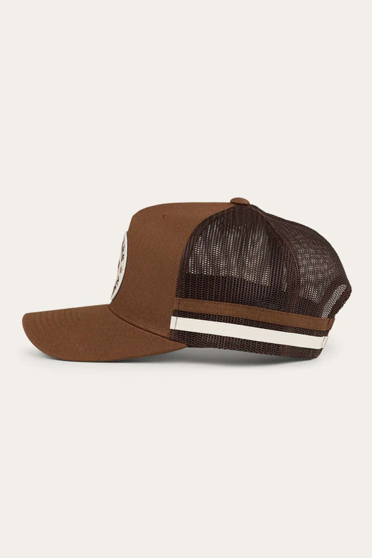 Side view of the Ringers Western Pendleton Trucker Cap featuring a brown front panel with a white logo, a curved brim, and an adjustable snapback crafted from reddish-brown mesh with two horizontal beige and white stripes. The cap is displayed against a light background.
