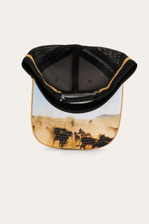 Product Description: The Ringers Western Pendleton Trucker Cap is a black mesh trucker cap with a curved brim, featuring a panoramic scene of cattle being herded across a dusty field printed on the underside. This hat includes tan trim, an adjustable snapback, and an embroidered badge. It looks new and unworn.