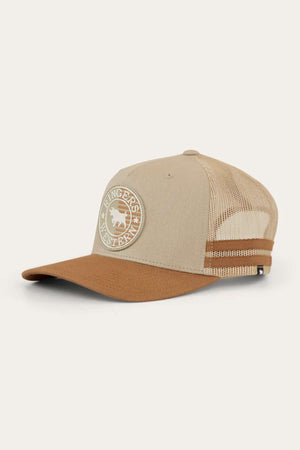 The Ringers Western Signature Bull Flag Trucker Cap features a beige and brown design with a mesh back and adjustable snapback closure. The front displays a circular patch with the text "Ringers Western" and an image of a bull. The brim and front panel are brown, while the rest of the hat is beige.