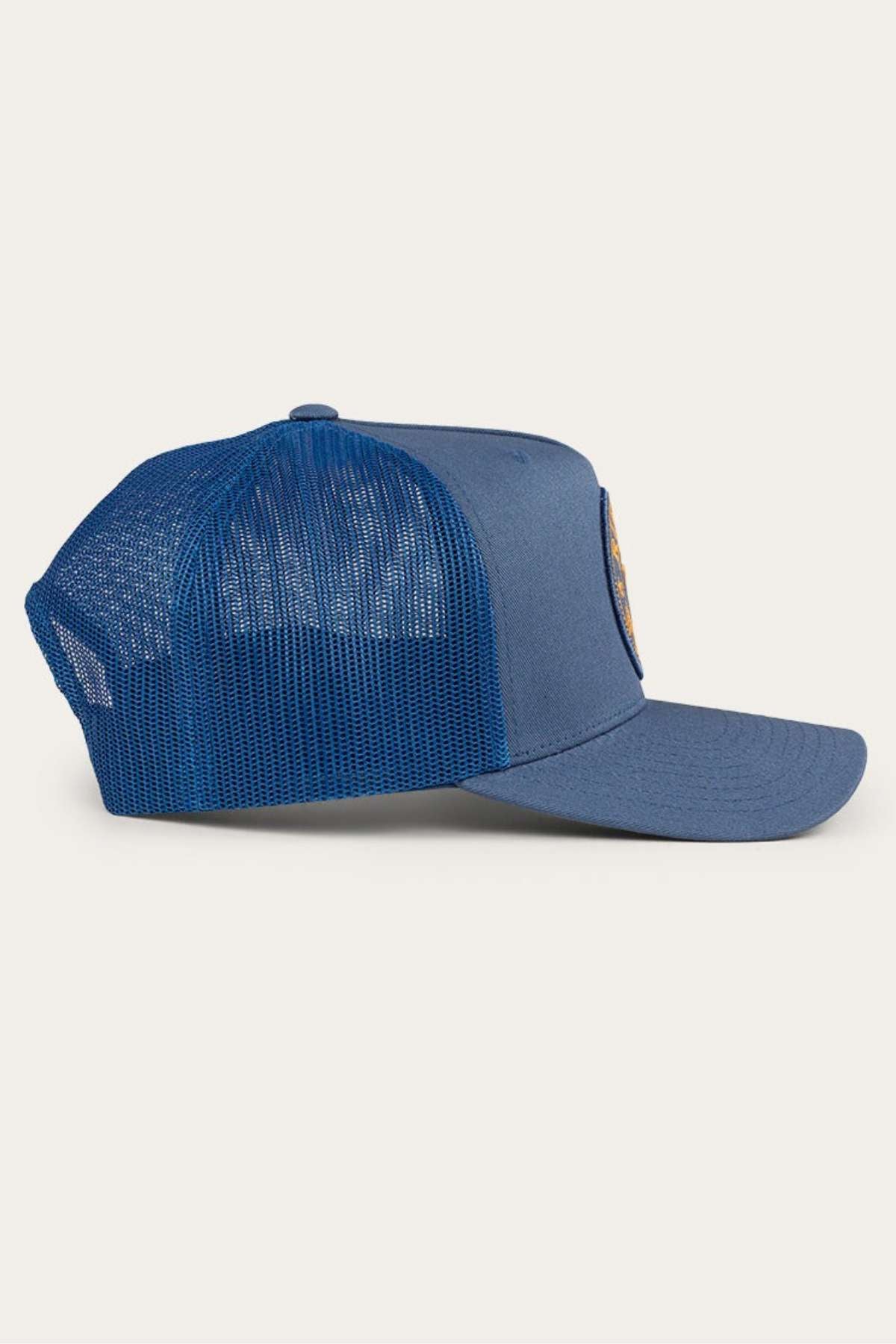Side view of the Ringers Western Signature Bull Trucker Cap showcasing its blue mesh design and curved bill. The cap features a plastic adjustable snapback closure at the back and a logo or patch on the front panel.