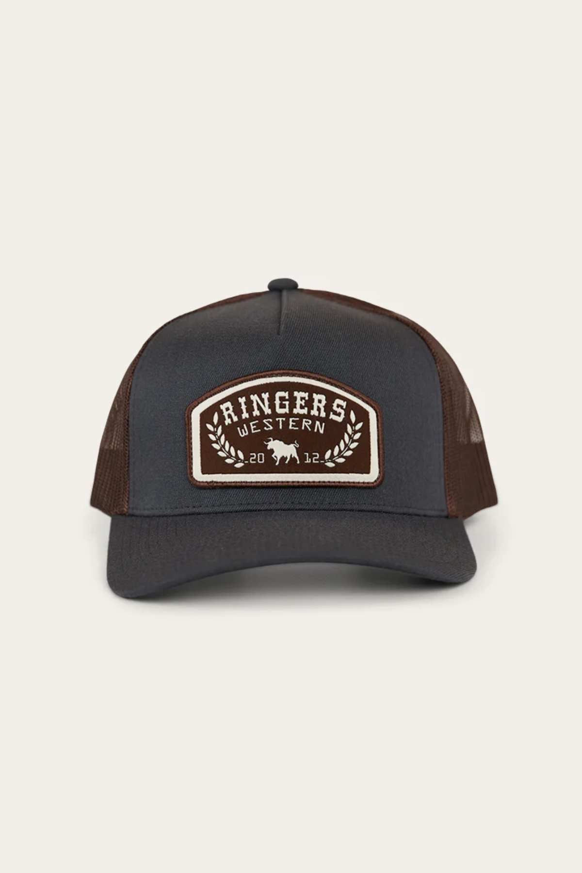 The Ringers Western Wheatbelt Wool Trucker Cap has a brown and black design with an adjustable strap, featuring a "Ringers Western" front patch with a bold bull illustration, the numbers "20" and "12," and decorative leaves.
