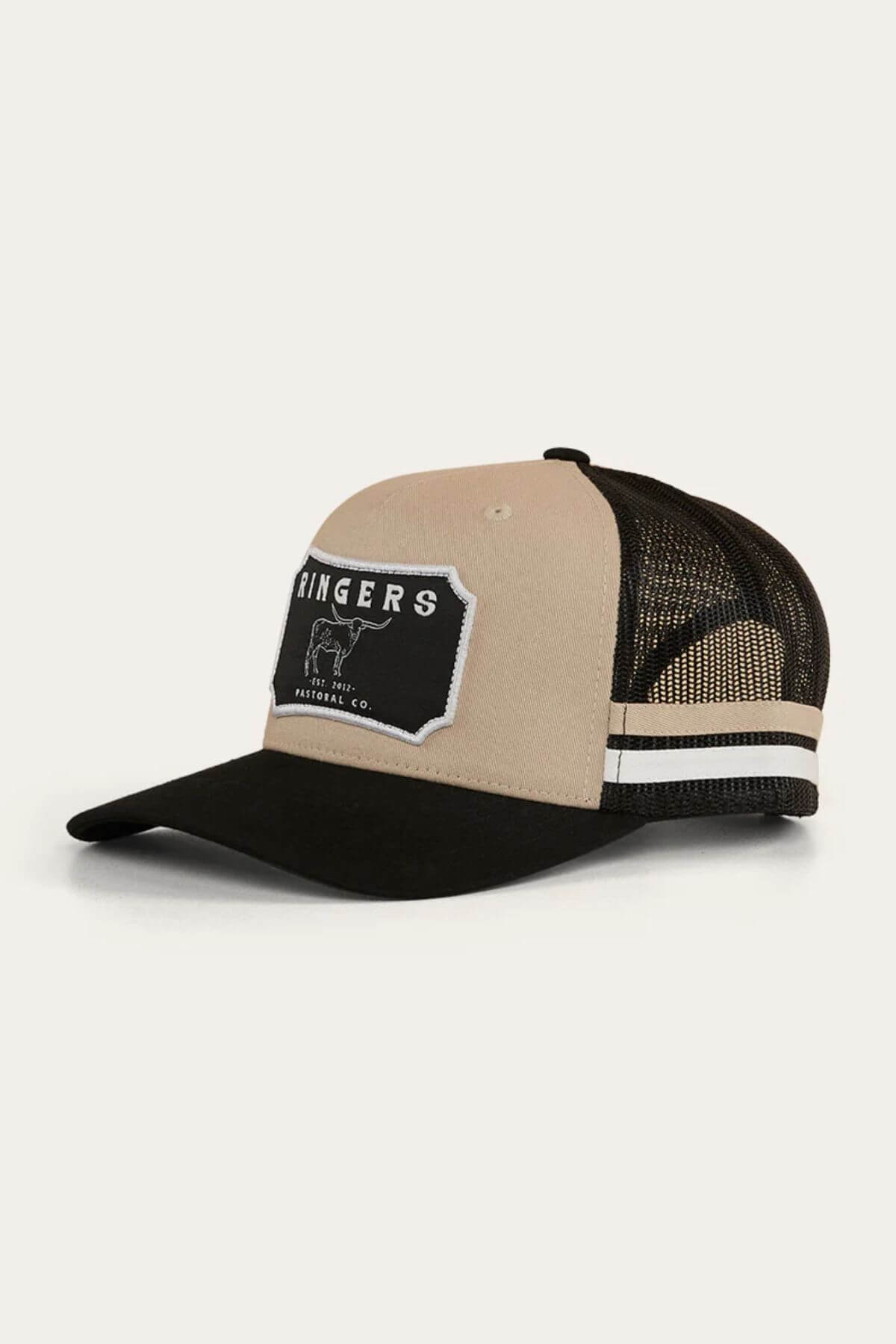 The Ringers Western Winston Trucker Cap features a beige and black design with a mesh back, black curved brim, white stripes above the brim, and an embroidered "RINGERS" patch with an illustrated bull on the front.