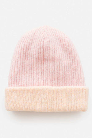 A light pink Rip Curl 2 Tone Reg Revo Beanie with a folded cuff rests against a plain white background. This tall beanie features a textured ribbed pattern, combining style and warmth.
