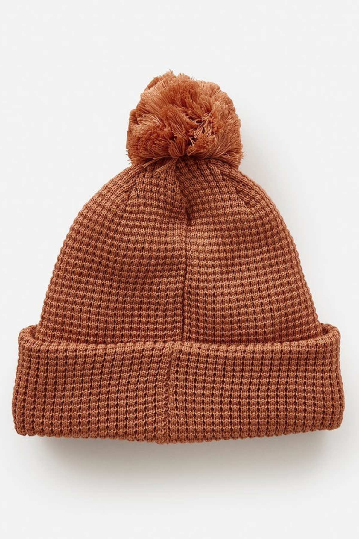 Rip Curl Anoeta Reg Pom Pom Beanie in brown knit with teddy fur lining, a large pom-pom on top, and a folded brim, displayed on a plain white background.