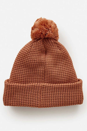 Rip Curl Anoeta Reg Pom Pom Beanie in brown knit with teddy fur lining, a large pom-pom on top, and a folded brim, displayed on a plain white background.