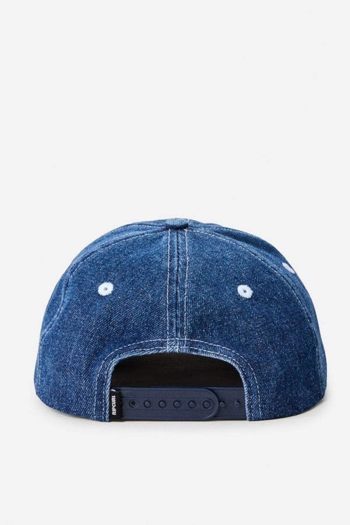 The Rip Curl Archive Denim SB Cap is a blue men's cap seen from the back, featuring white stitching, two ventilation holes, an adjustable navy snapback strap, and a subtle embroidered logo.