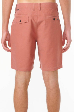 A person is shown from the waist down, wearing Rip Curl Boardwalk Epic Mix shorts in salmon, featuring quick-dry fabric, belt loops, and two back pockets—one with a button—set against a plain white background.