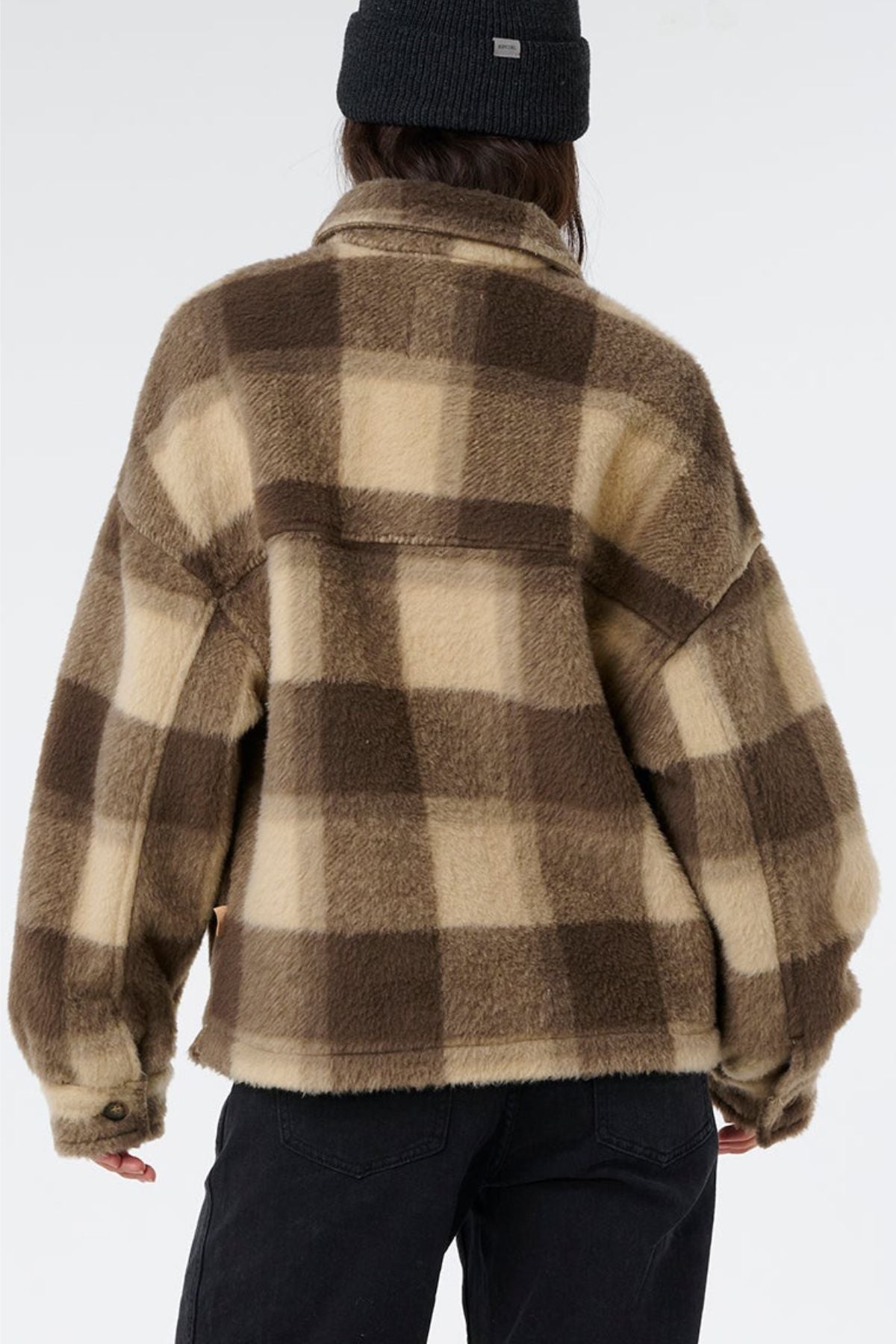 A person wearing a fuzzy, brown and beige Rip Curl Cala Nights Check Jacket with premium construction and a black beanie is shown from the back against a plain light background.