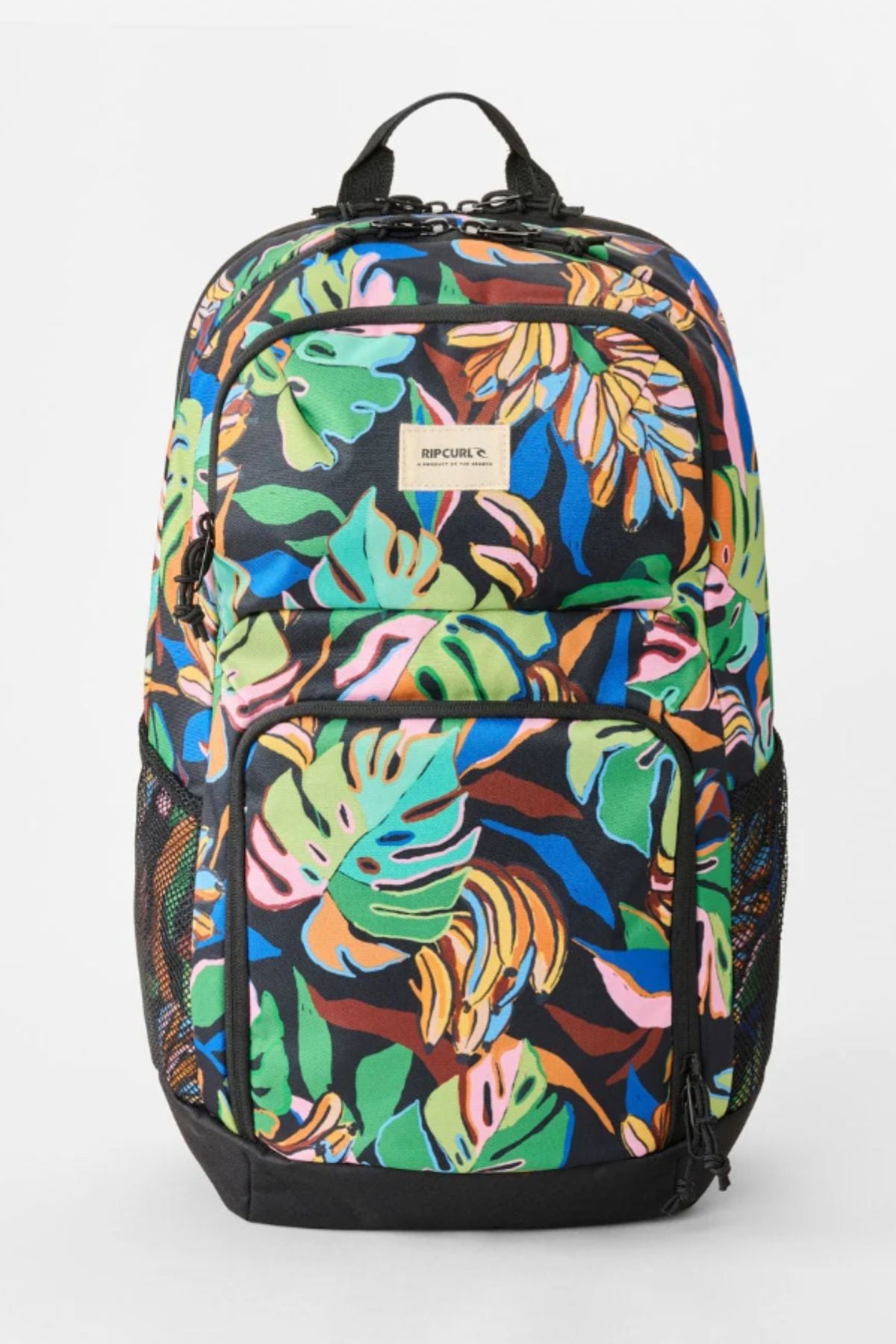 The Rip Curl Chaser 33L Backpack features a vibrant tropical leaf pattern in green, orange, blue, and pink, made from recycled polyester. It has multiple zippered compartments, mesh side pockets, and a beige RIP CURL label on the front.