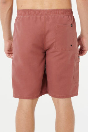A person is shown from the back wearing Rip Curl Classic Surf Cargo Shorts in rust, featuring a relaxed fit, elastic waistband, and a single square right back pocket, set against a plain white background.