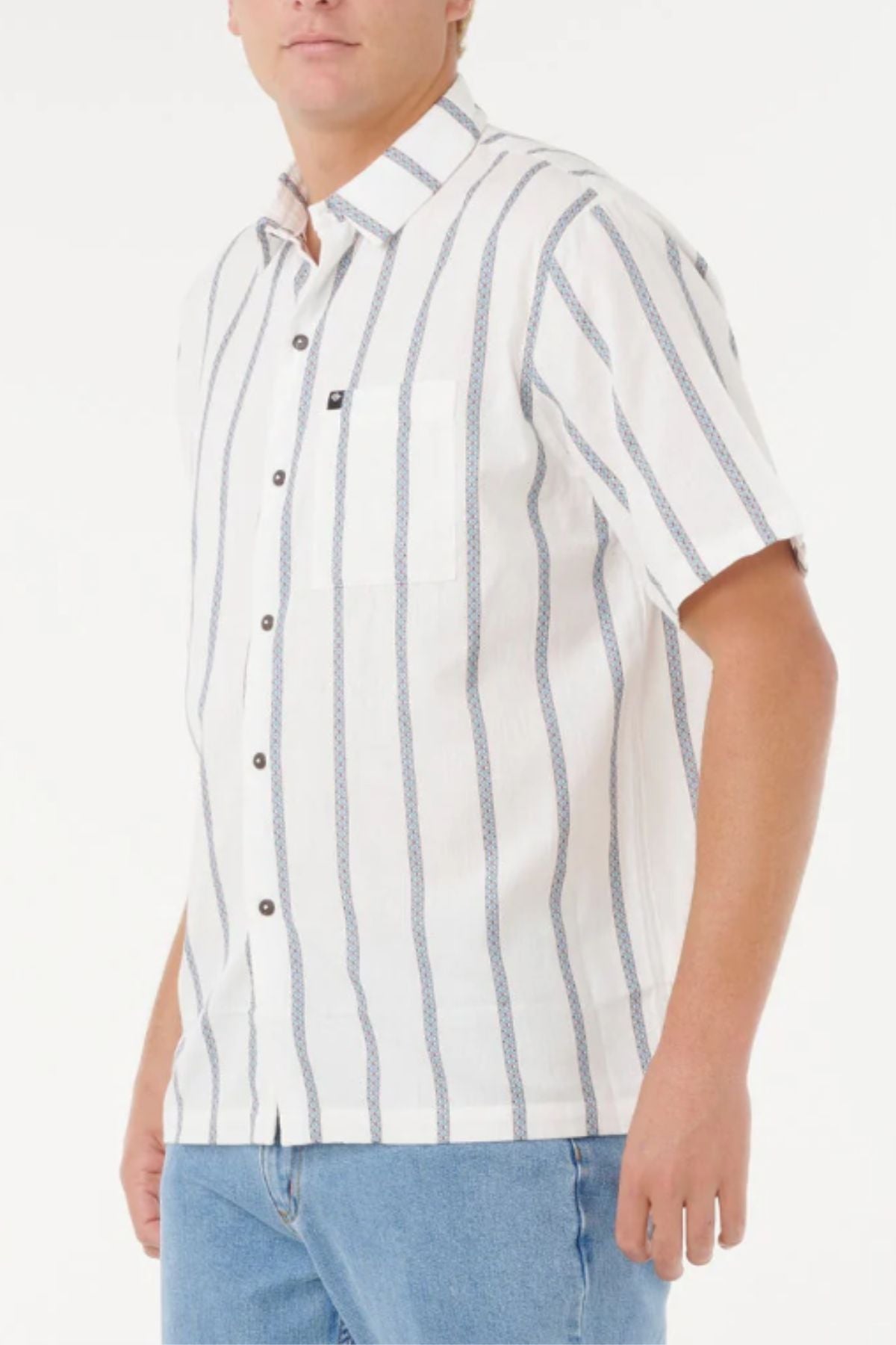A man wearing the Rip Curl Classic Surf Stripe Short Sleeve Shirt with blue vertical stripes and light blue jeans stands against a plain white background.