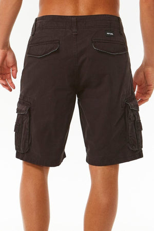 A person wearing the Rip Curl Classic Surf Trail Cargo Short is standing with their back to the camera. The dark brown, relaxed-fit shorts feature multiple pockets, including two back flap pockets and two side cargo pockets with flap closures. The person has a tan complexion and is shirtless.