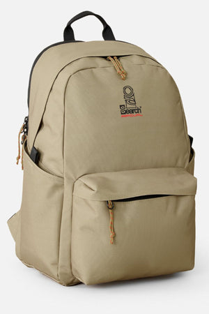 The Rip Curl Crusha 30L Search Backpack in khaki features front and side pockets, black zippers and handle, plus a small "Search" logo. Ideal for daily use or as a stylish laptop backpack.