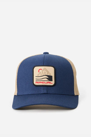 The Rip Curl Custom Curve Trucker is a blue and beige cotton twill hat with a curved peak, front patch of a surfer riding a wave, and "Ripcurl" below, shown on a plain white background.