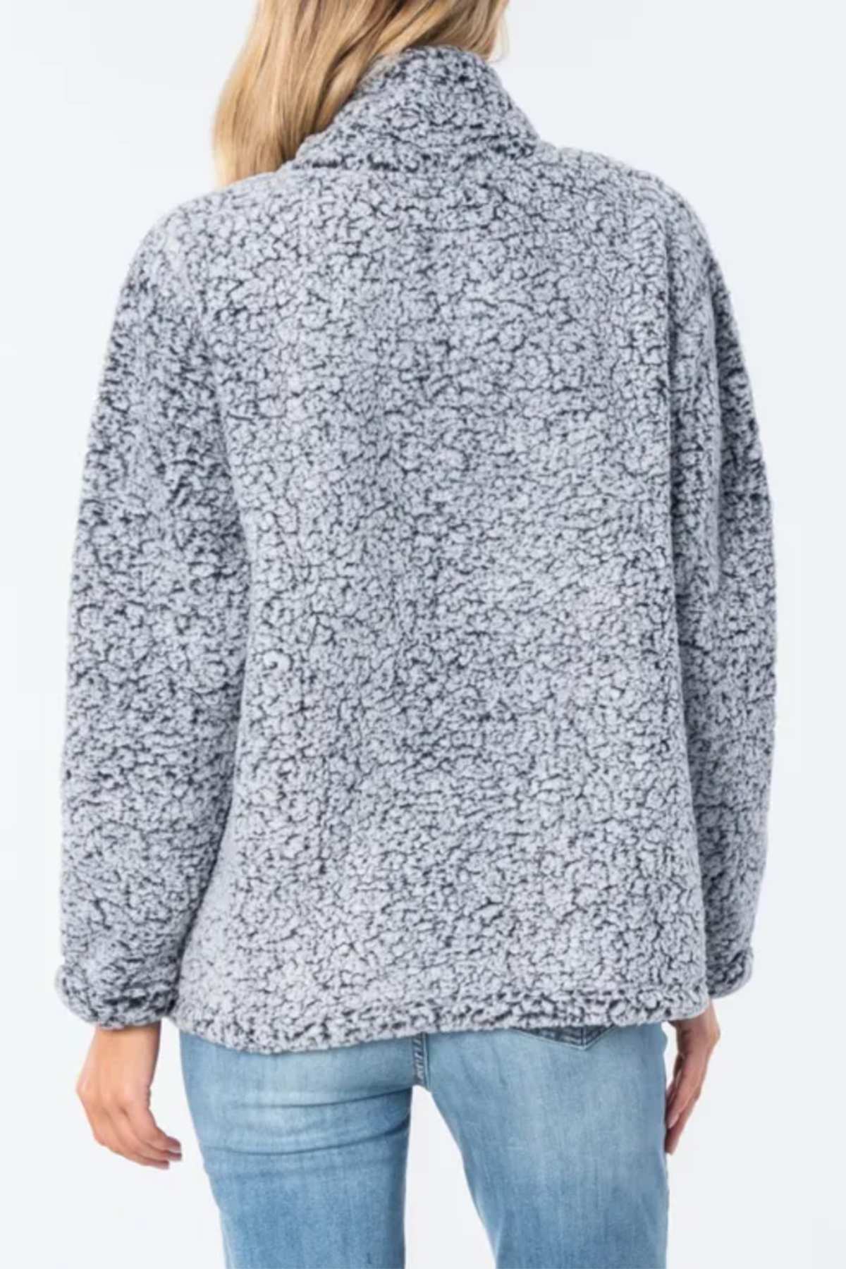 A person is seen from the back wearing the Rip Curl Dark N Stormy 1/4 Zip Crew in light gray fleece with blue jeans, set against a plain, light background.