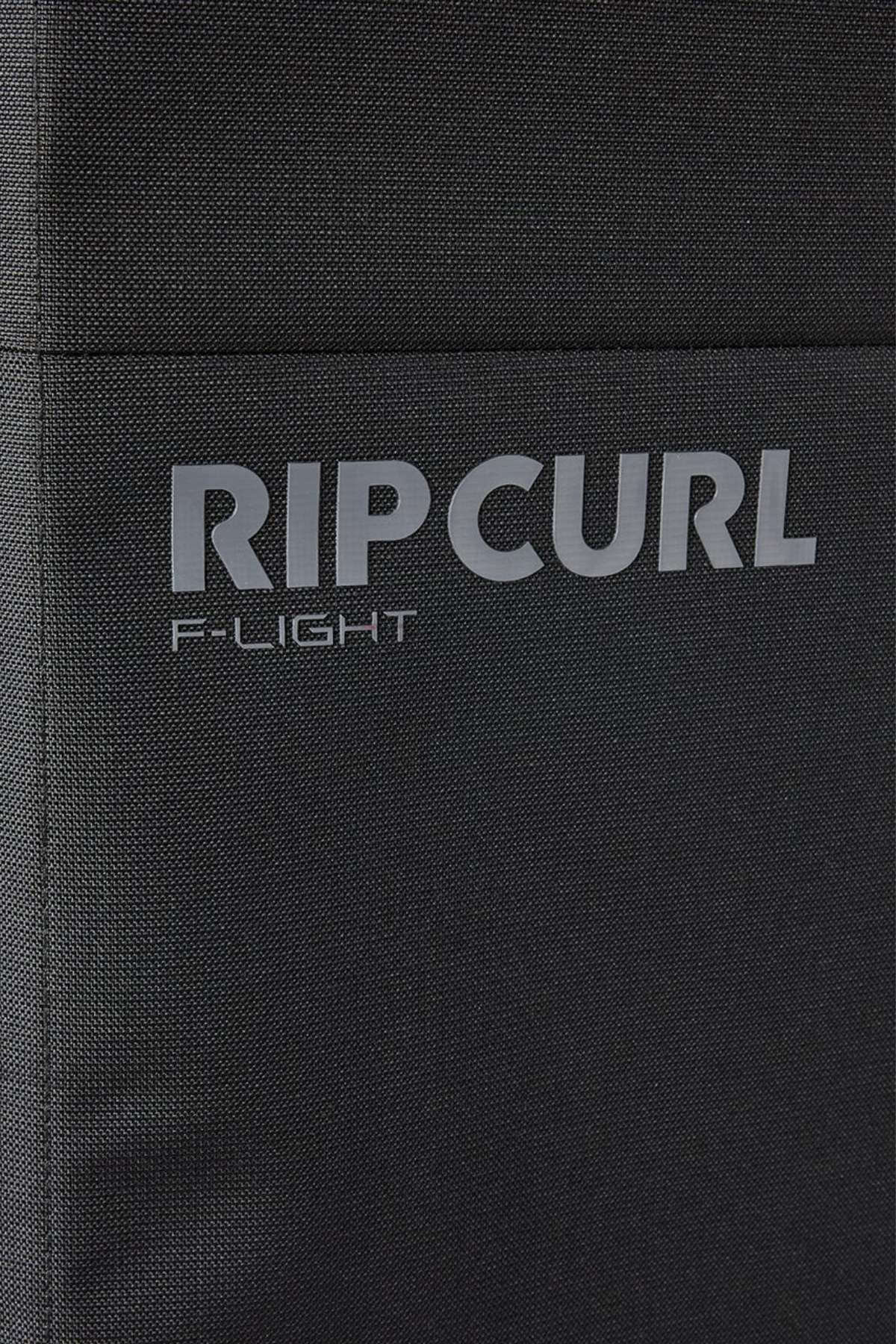 Close-up of the black textured fabric on the Rip Curl F-Light 90L Check-In Wheeled Travel Bag, featuring "RIP CURL" and "F-LIGHT" printed in gray capital letters.