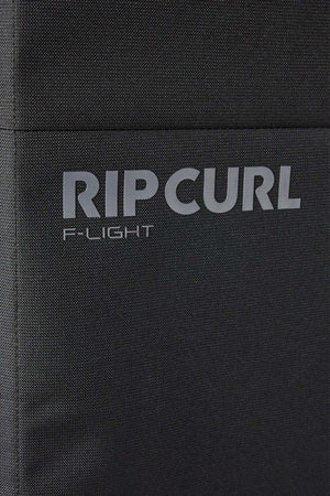 Close-up of the black textured fabric on the Rip Curl F-Light 90L Check-In Wheeled Travel Bag, featuring "RIP CURL" and "F-LIGHT" printed in gray capital letters.