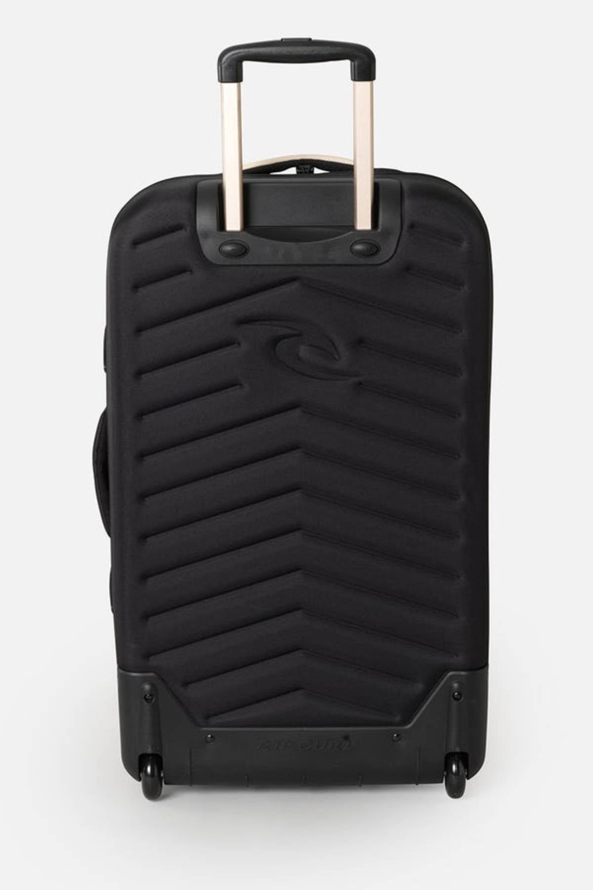 The Rip Curl F-Light Global 100L Soleil Travel Bag in black has a zigzag textured front, is made from recycled polyester, features an extended telescopic handle, two wheels for easy maneuverability, and internal compression straps. It stands upright against a plain gray background.