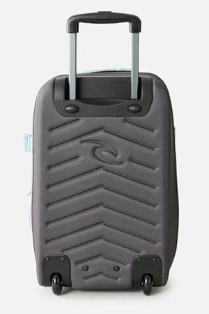 The Rip Curl F-Light Transit 50L Sessions Travel Bag features a gray, chevron-patterned hard shell, an extended telescopic handle, two black wheels, and a spacious 50L capacity for convenient storage.