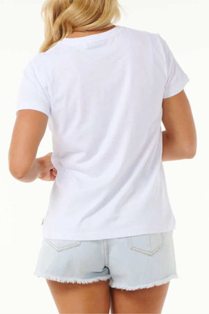 A person with long, blonde hair is facing away from the camera. They are wearing a plain white tee (Rip Curl High Tide Psychic Standard Tee) and Rip Curl High Tide light blue denim shorts with frayed hems. The background is white and unobtrusive.