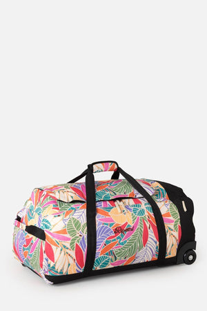 The Rip Curl Jupiter 80L Mixed Travel Bag is a large rolling duffel with a vibrant multicolor leaf pattern on recycled polyester. It includes black straps, smooth wheels, and a telescopic handle, with its colorful design standing out against a plain white background.