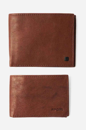 Two brown Rip Curl K-Roo RFID 2 in 1 wallets are placed against a white background. The top slim wallet is accented with a subtle logo tag, while the bottom one displays the "RIP CURL" brand in black lettering. Both boast RFID protection, appear brand new, and are meticulously crafted.