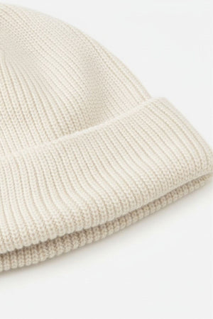 A close-up of the Rip Curl Oceanic Reg Beanie, a beige knit hat with a folded brim, displayed on a plain white background—ideal for keeping warm after water sports.