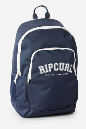 The Rip Curl Ozone 2.0 30L Backpack is navy blue with white zippers, trim, front and side mesh pockets, a laptop section, and "RIP CURL AUTHENTIC SURFING COMPANY" printed in white on the front.
