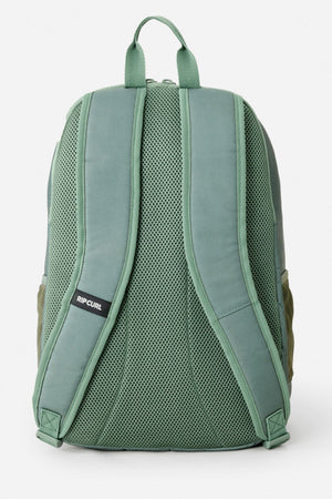 The Rip Curl Ozone 2.0 30L Backpack is shown from the back in green, with padded straps, a mesh back panel, and a small "Rip Curl" logo on the left strap, all set against a plain white background.