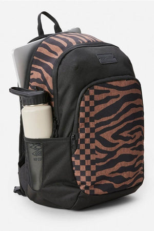 The Rip Curl Ozone 2.0 30L Backpack features a spacious black design with brown zebra and checkerboard patterns, organiser pockets, a mesh side pocket holding a cream water bottle, and a partially visible laptop in the main compartment.