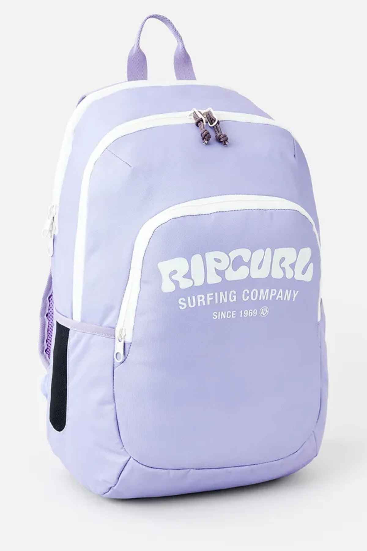 A light purple Rip Curl Ozone 2.0 30L Backpack with "SURFING COMPANY SINCE 1969" printed in white on the front. This durable polyester bag features multiple compartments, white zippers, a side pocket, and has a top handle along with visible shoulder straps.