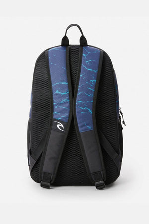 The Rip Curl Ozone 30L Faded Slant Backpack is shown from the back with two padded shoulder straps featuring blue and white wave patterns, a small white logo, and organiser pockets against a plain white background.