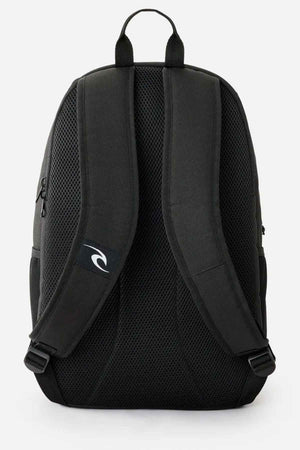 The Rip Curl Ozone 30L School Backpack in black is made from recycled polyester and features padded shoulder straps and a mesh back for enhanced comfort. It has a small logo on one strap and includes a practical top handle, making it ideal for simple yet functional everyday use.