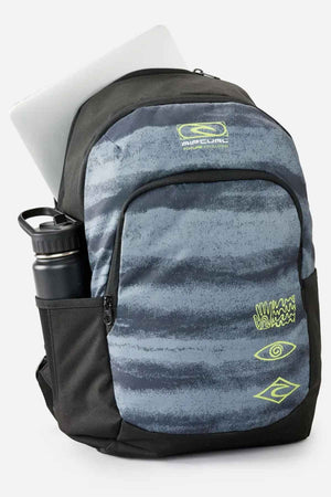 The Rip Curl Ozone 30L School Backpack, made from recycled polyester, features a black and gray pattern with lime green accents. Designed for school use, it has multiple pockets, including a top compartment for a laptop and a side pocket perfect for holding a black water bottle. The image is set against a plain white background.