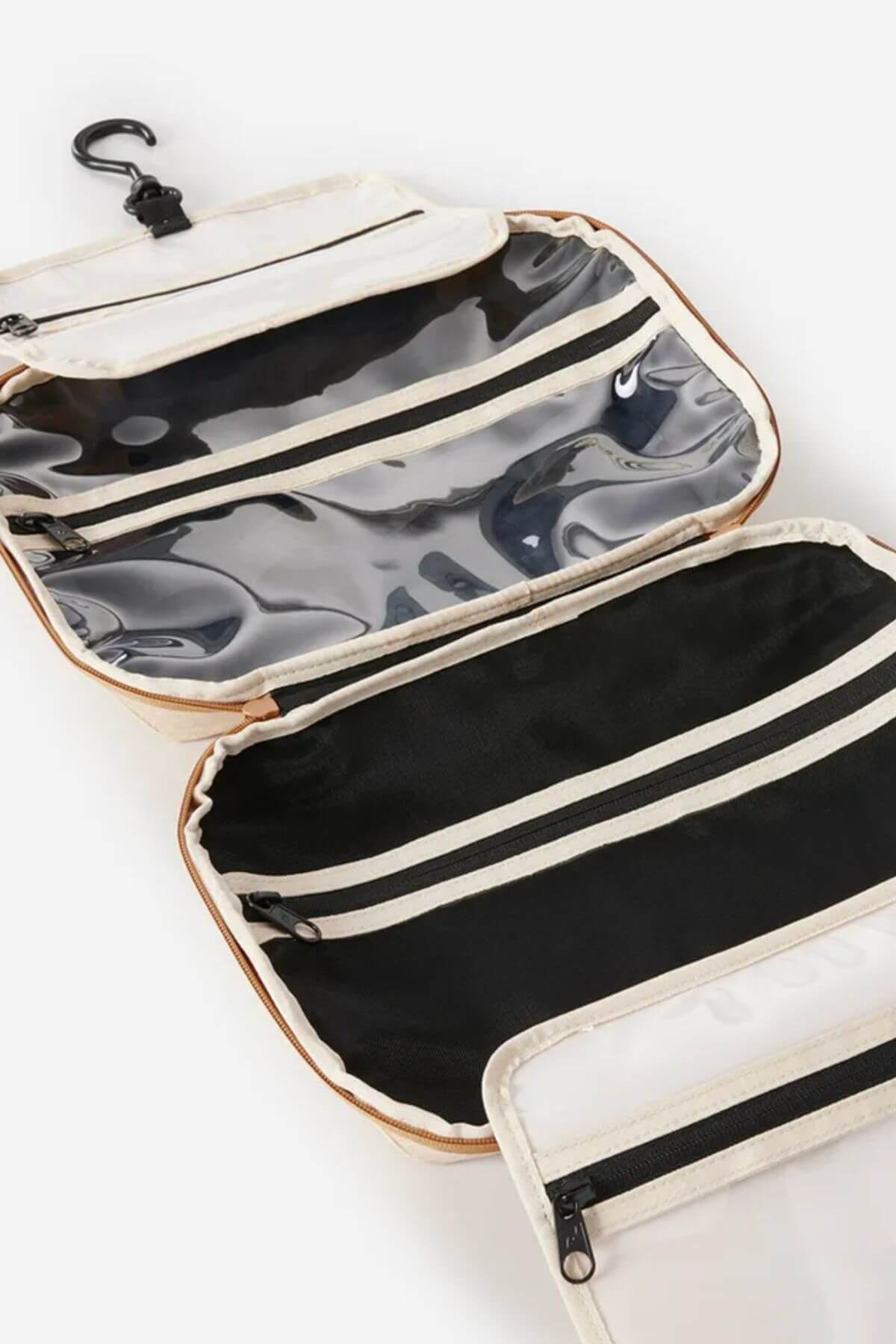 The Rip Curl Ultimate Beauty Case is made of recycled polyester and features clear zippered compartments, an internal mesh organizer, and a black top hook for hanging. The bag is shown laid flat with empty compartments.