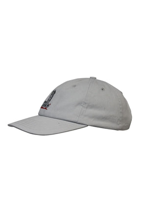 The Rip Curl Searchers SB Cap is a light gray cotton twill cap with a curved brim, visible stitching, eyelets, and a small embroidered logo with partial text on the front, shown from the side.