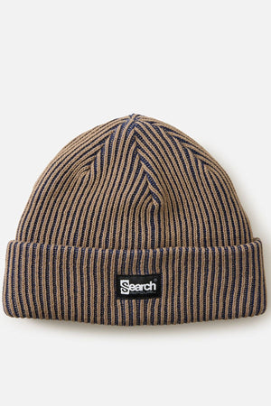 The Rip Curl Search Chunky Reg Beanie is a brown and navy ribbed knit winter hat with a folded brim, featuring a black and white rectangular "Search" logo patch on the front.