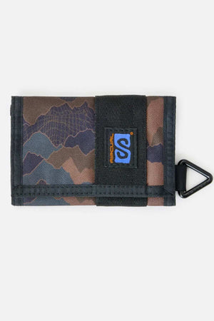 The Rip Curl Search Surf Wallet is a tri-fold fabric wallet with blue and brown camouflage, black trim, Velcro closure, triangle clip, and logo patch—perfect for beach-goers seeking style and convenience.