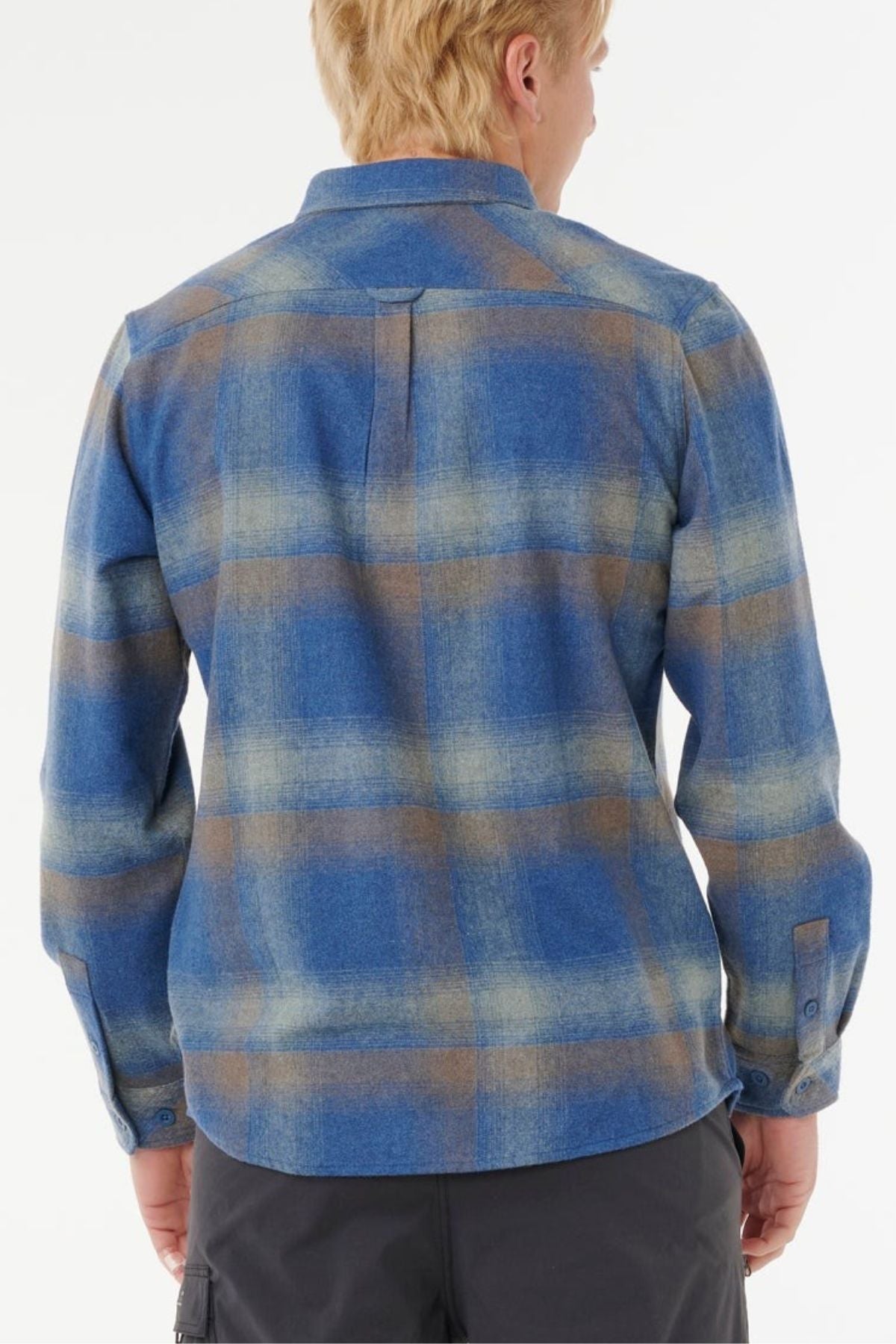 A person with short blond hair is shown from the back, wearing a blue and brown Rip Curl Search Wool Flannel shirt and dark pants against a plain white background.