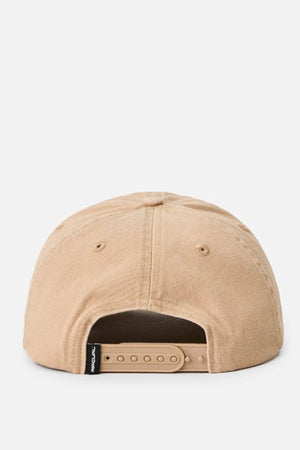 The Rip Curl Searchers SB Cap is a tan unstructured cap, shown from the back with an adjustable plastic strap and a small black tag on the left side above the opening.