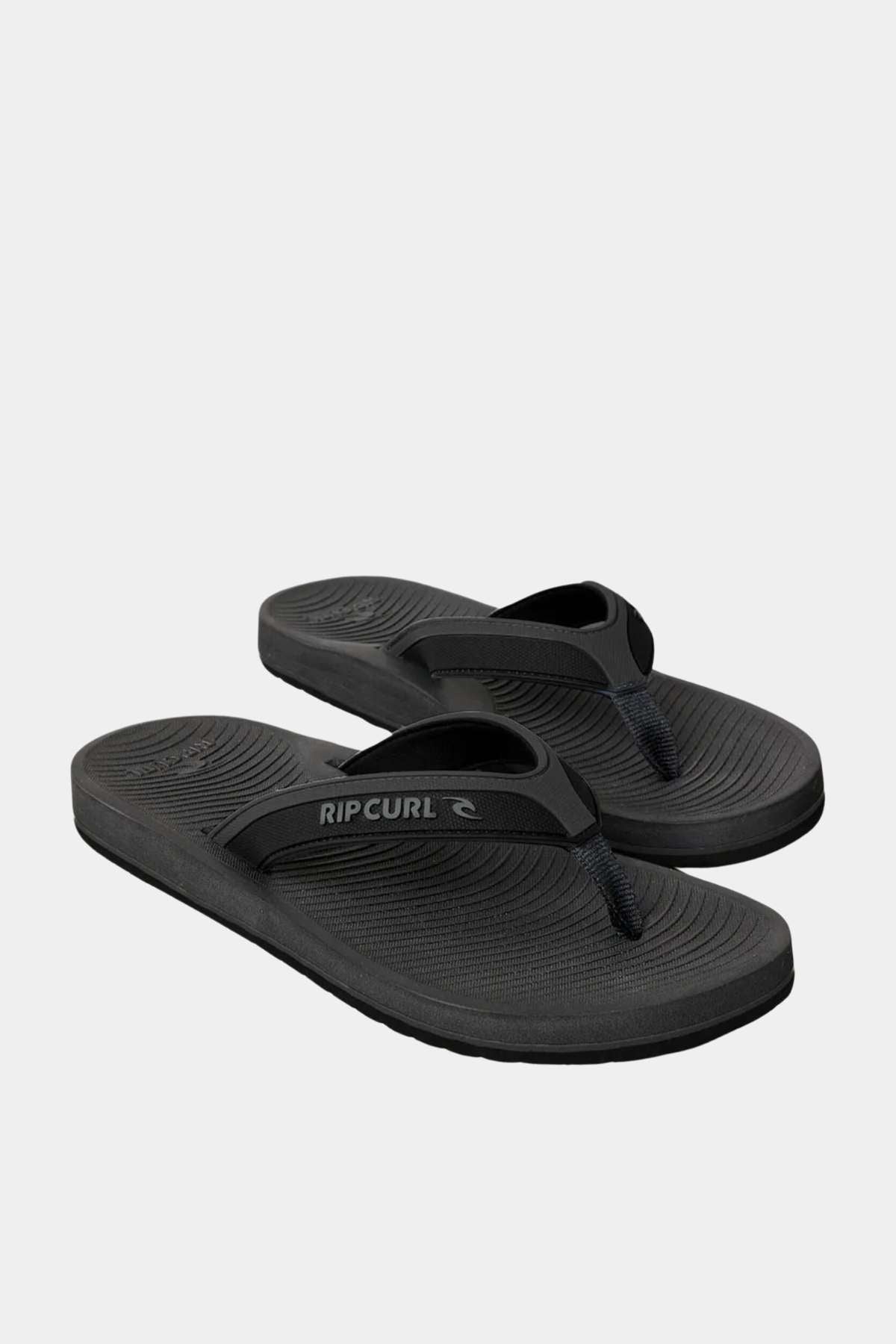 The Rip Curl Tunnels Bloom Thongs are black flip-flops with textured BLOOM algae foam footbeds and classic thong straps, shown on a plain white background.